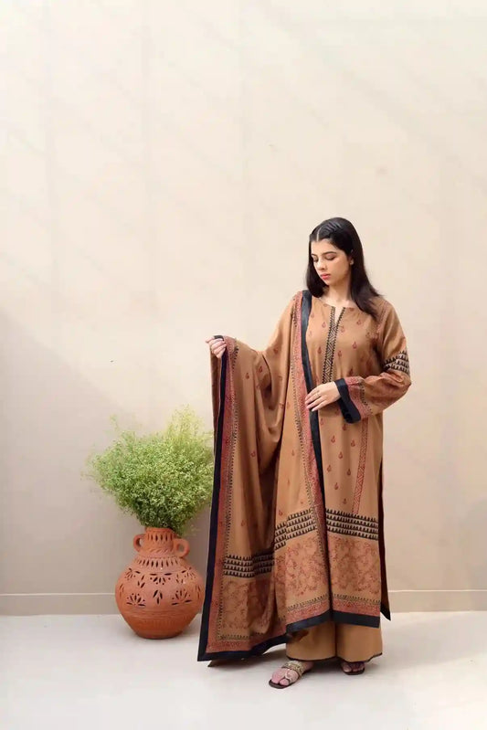 Woman in a traditional outfit holding a dupatta against a plain background